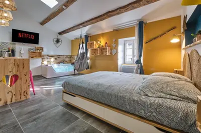 a bedroom with a bed and a yellow wall at Place Carnot - studio tout équipé avec jacuzzi proche toutes commodités in Carcassonne