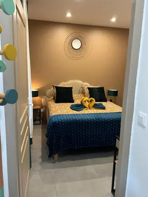 a bedroom with a bed with a yellow ribbon on it at La CORSA CHAMBRE FAMILIALE DELUXE in Narbonne