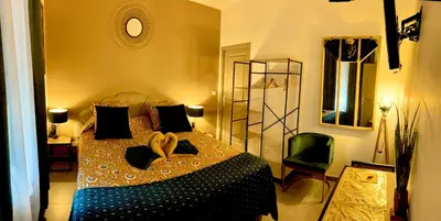 a bedroom with a bed in a room with a mirror at La CORSA CHAMBRE FAMILIALE DELUXE in Narbonne
