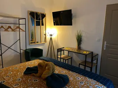 a bedroom with a bed with a towel on it at La CORSA CHAMBRE FAMILIALE DELUXE in Narbonne