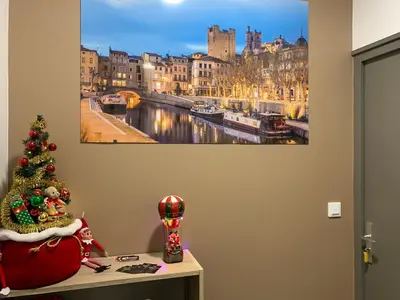 a christmas tree on a table with a picture of a city at La CORSA CHAMBRE FAMILIALE DELUXE in Narbonne