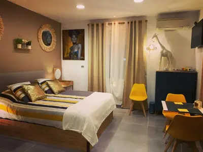 a bedroom with a bed and a table and chairs at LA DI MARIA in Narbonne