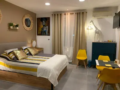 a bedroom with a bed and a table and chairs at LA DI MARIA in Narbonne