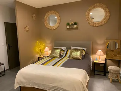 a bedroom with a bed with two mirrors on the wall at LA DI MARIA in Narbonne