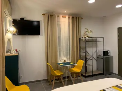 a room with a table and chairs and a television at LA DI MARIA in Narbonne