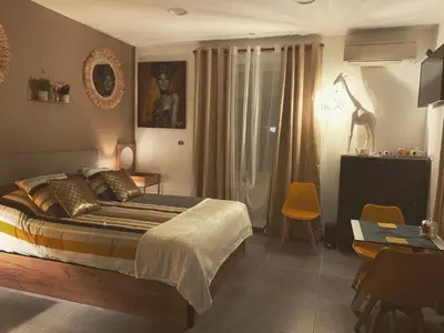a bedroom with a bed and a table and chairs at LA DI MARIA in Narbonne
