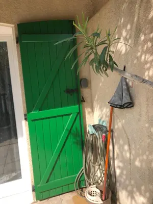 a green door on the side of a house at Villa à 50 m de la plage du Grazel pour 6 personnes in Gruissan