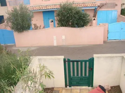 a green gate in front of a fence at Villa à 50 m de la plage du Grazel pour 6 personnes in Gruissan
