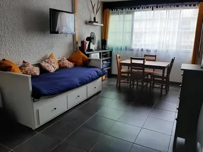 a bedroom with a bed with a table and a dining room at Chaleureux studio en bord de mer in Port-la-Nouvelle