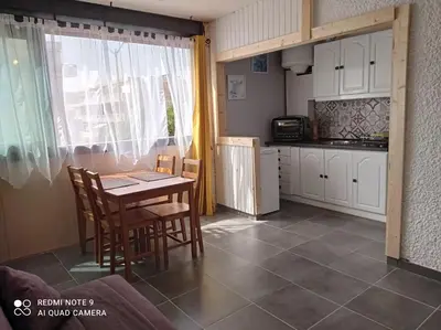 a kitchen with a table and chairs in a room at Chaleureux studio en bord de mer in Port-la-Nouvelle