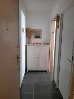 a hallway with a white cabinet and a tile floor at Chaleureux studio en bord de mer in Port-la-Nouvelle