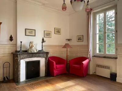 a living room with two red chairs and a fireplace at Große Ferienwohnung am Canal du MIDI mit Dachterrrasse in Homps