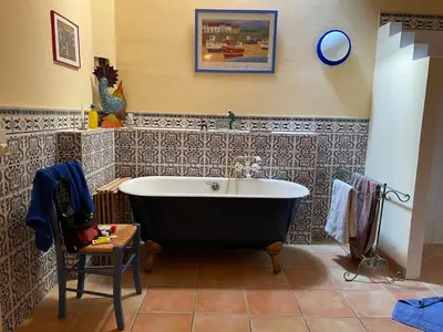 a bath tub in a bathroom with a tile wall at Große Ferienwohnung am Canal du MIDI mit Dachterrrasse in Homps