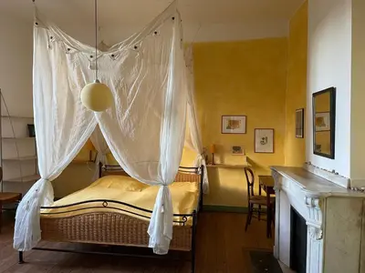 a bedroom with a canopy bed with a table at Große Ferienwohnung am Canal du MIDI mit Dachterrrasse in Homps
