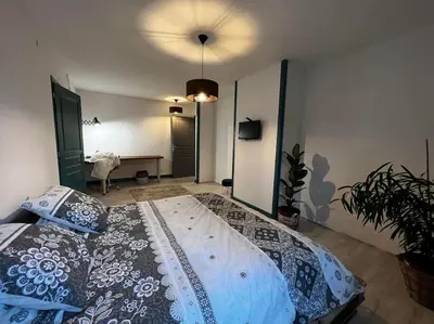 a bedroom with a large bed in a room at Gite à la ferme avec jacuzzi et piscine chauffée in Saint-Félix-de-Tournegat