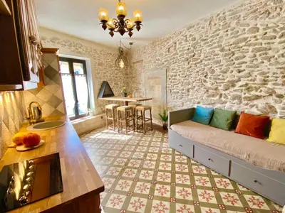 a living room with a couch and a stone wall at La Maison des Templiers ~ Ostal Médiéval ~ Logis enchantés in Carcassonne