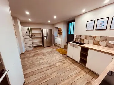 a kitchen with wooden floors and a refrigerator at Gites entre 2 rives in Montolieu