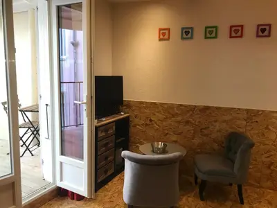 a living room with a chair and a tv and a stool at New Boat in Narbonne