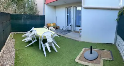 a patio with a table and chairs on the grass at Narbonne centre T2 avec jardinet et parking in Narbonne