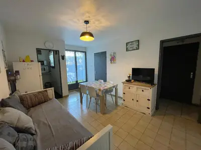 a living room with a couch and a table at Narbonne centre T2 avec jardinet et parking in Narbonne