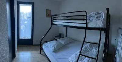 a bedroom with two bunk beds and a window at Narbonne centre T2 avec jardinet et parking in Narbonne