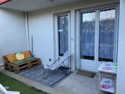 a porch with a chair and a couch on a patio at Narbonne centre T2 avec jardinet et parking in Narbonne