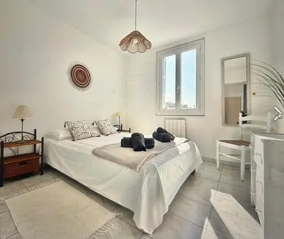 a bedroom with a bed with white sheets and a lamp at Centre Carcassonne apartment with private sunny terrace in Carcassonne