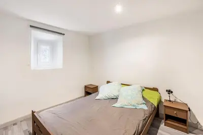 a bedroom with white walls and a bed with two pillows at Maison atypique dans circulade in Bram