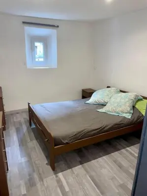 a bedroom with a bed in a room with a window at Maison atypique dans circulade in Bram