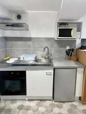 a small kitchen with a sink and a microwave at Maison atypique dans circulade in Bram