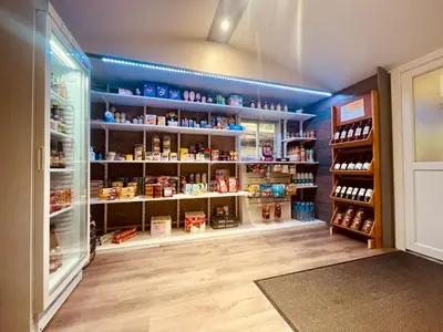 a store aisle with blue walls and shelves of food at Flower Camping La Pibola in Camon