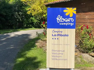 a sign for a landscaping leagueipedia next to a road at Flower Camping La Pibola in Camon