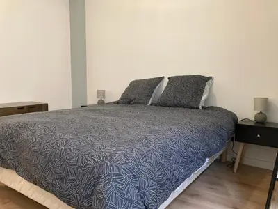 a bedroom with a bed with a blue and white comforter at CARC'APPART Appartements à Carcassonne in Carcassonne