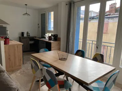 a kitchen with a wooden table and chairs and a table at CARC'APPART Appartements à Carcassonne in Carcassonne