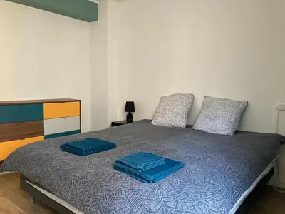 a bed with two blue pillows on top of it at CARC'APPART Appartements à Carcassonne in Carcassonne
