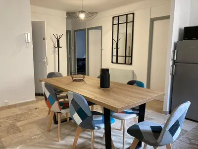 a dining room with a wooden table and chairs at CARC'APPART Appartements à Carcassonne in Carcassonne