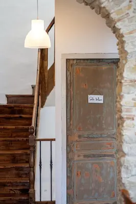 an old door with a sign on it next to stairs at Charme au cœur des vignes in Malras