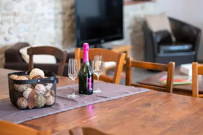 a table with a bottle of wine and two wine glasses at Charme au cœur des vignes in Malras
