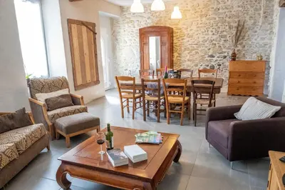 a living room with a couch and a table and chairs at Charme au cœur des vignes in Malras