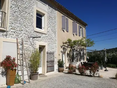 a stone house with potted plants in front of it at Charme au cœur des vignes in Malras