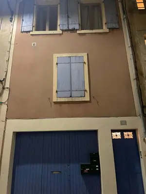 a building with a blue garage door and two windows at Studio in Carcassonne