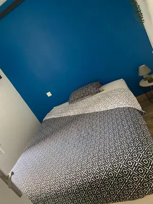 a bed in a room with a blue wall at Le Cosy in Narbonne