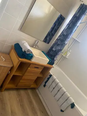 a bathroom with a sink and a mirror and a tub at Le Cosy in Narbonne