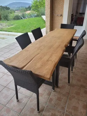 a wooden table with chairs around it on a patio at B&B BonjourSoleil in Tourouzelle