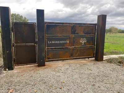 an old metal gate with the words la mausheastern at DOMAINE LA MASQUIERETTE in Villepinte