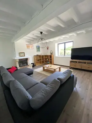 a living room with a large couch and a television at DOMAINE LA MASQUIERETTE in Villepinte