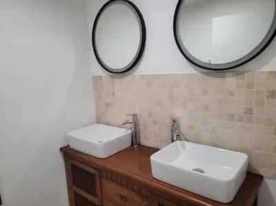 a bathroom with two sinks and two mirrors at maison des vendangeurs in Villarzel-Cabardès