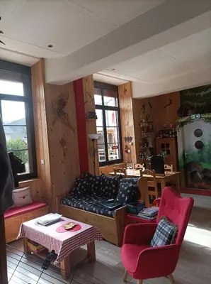a living room with a couch and a table at Le sapin rouge - Restaurant - bar - chambres d'hôtes in Artigues