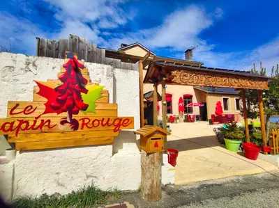a restaurant with a christmas sign on the side of a building at Le sapin rouge - Restaurant - bar - chambres d'hôtes in Artigues