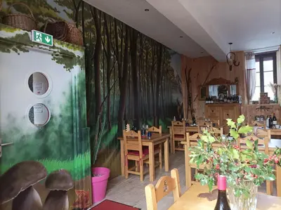 a restaurant with tables and chairs and a green wall at Le sapin rouge - Restaurant - bar - chambres d'hôtes in Artigues